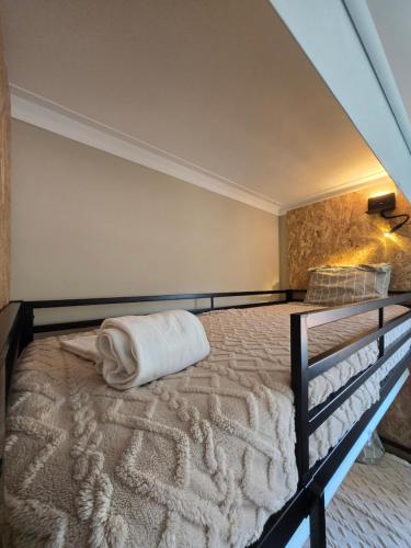 a bed with a white pillow on top of it at Mãe Maria House Guest House in Vila Chã