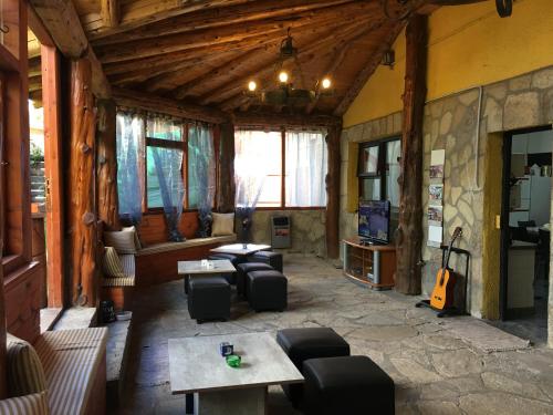 a living room with couches and tables and a guitar at Italia Inn Hostel in San Carlos de Bariloche