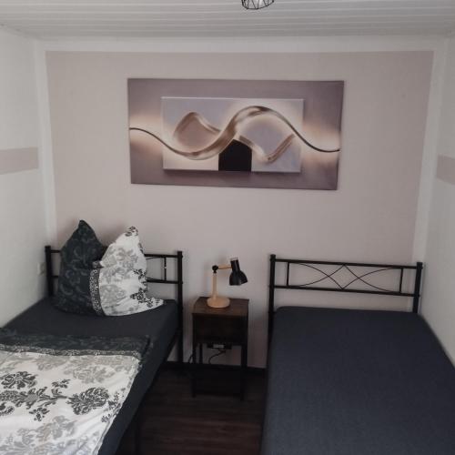 a bedroom with two beds and a table with a lamp at Fewo Am Waldrand in Heideblick