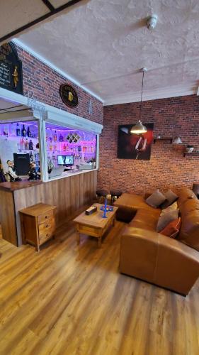 a living room with a couch and a bar at Leecliff Guest House in Blackpool