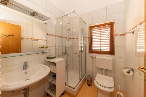 a bathroom with a toilet and a sink and a shower at Villa Zubčić in Zadar