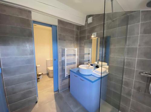 a bathroom with two sinks and a glass shower at La terrasse des oiseaux in Taillet