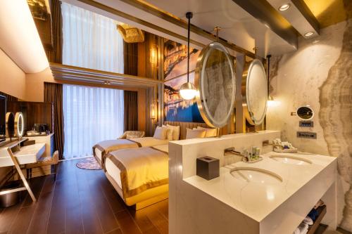 a hotel room with a bed and a sink and a bathroom at Merit Starlit Hotel & Residences in Budva