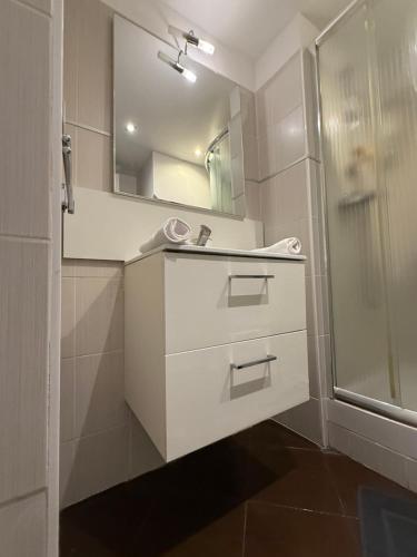 a white bathroom with a sink and a shower at Paula suite avec terrasse-Croisette, Plage Festival Palais in Cannes