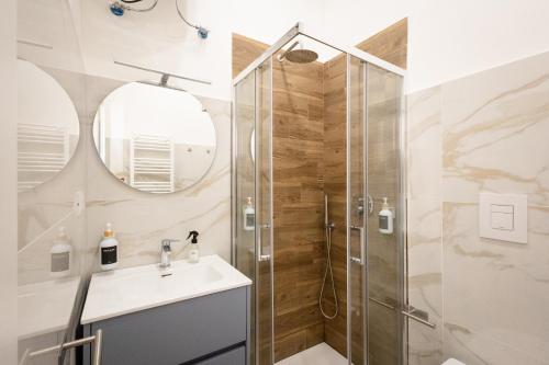 a bathroom with a shower and a sink and a mirror at Azzurra Rooms Suite in Battipaglia