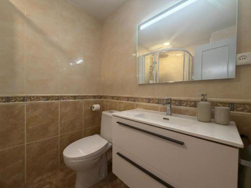 a bathroom with a toilet and a sink and a mirror at Tropical Salou in Salou