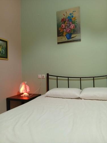 a bedroom with a bed and a table with a lamp at Irida mariaSmall studio in Agios Ioannis Pelio