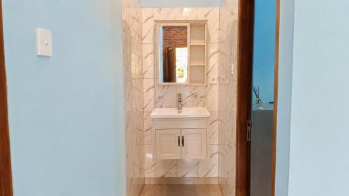 a bathroom with a white sink and a mirror at Mulia Home Stay in Nusa Dua