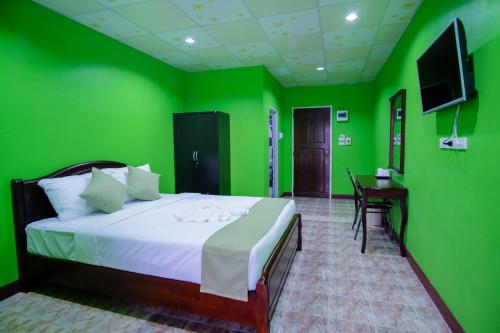 Habitación verde con cama y escritorio. en Sweet Dreams Hometel, en Krabi