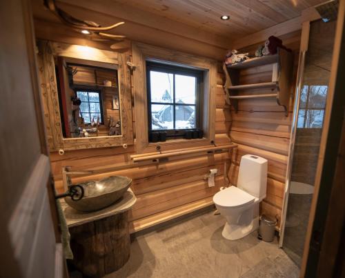 a wooden bathroom with a sink and a toilet at Langedrag Naturpark in Tunhovd
