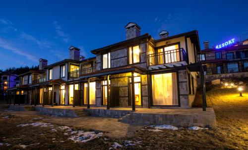 a large house with lights on at night at Holiday Village COOP Dobrinishte in Dobrinishte