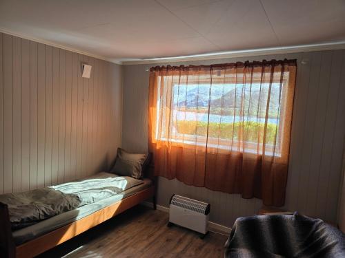 a small room with a window and a bed at Fjord & Fjell Idyll in Tunheim