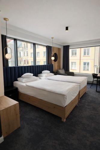 a bedroom with two beds and a large window at Apartamenty Branicka in Białystok