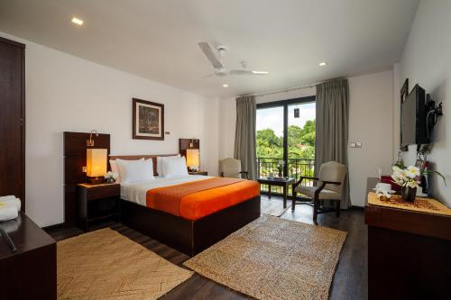 a hotel room with a bed and a balcony at Fox Jaffna by Fox Resorts - Boutique Heritage Luxury in Jaffna