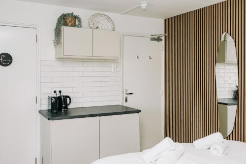 a kitchen with white cabinets and a bed in a room at Divi Divi Zandvoort in Zandvoort