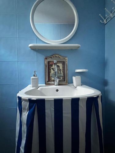 a bathroom with a white sink with a mirror at Sufiko Studios - Thea in Armenistis