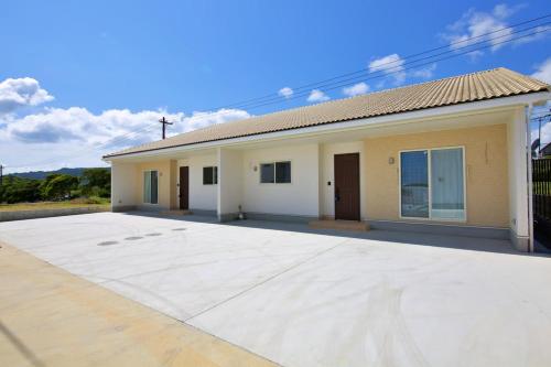 a house with a large driveway in front of it at Dual Residence Nakijin A in Koechi