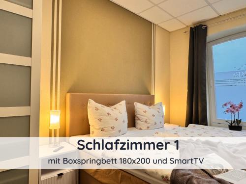 a bedroom with a bed with pillows and a window at Ferienwohnung Auszeit Harz in Bad Sachsa