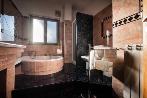 a bathroom with a tub and a sink at Orchidea Catania in San Giovanni la Punta