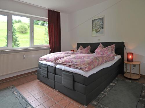 a bedroom with a large bed with pink pillows at Apartment in Lennestadt for 2 Person in Lennestadt