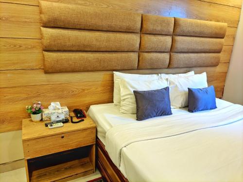 a bedroom with a bed with a wooden headboard at Hotel Afford Inn in Dhaka