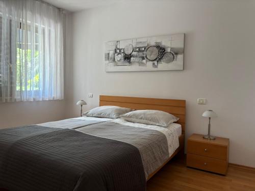 a bedroom with a bed and a painting on the wall at Apartma Eva in Portorož