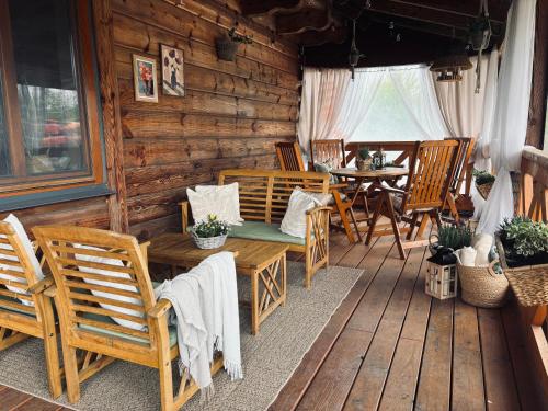 a wooden cabin with a table and chairs on a porch at Józwówka Swornegacie in Swornegacie