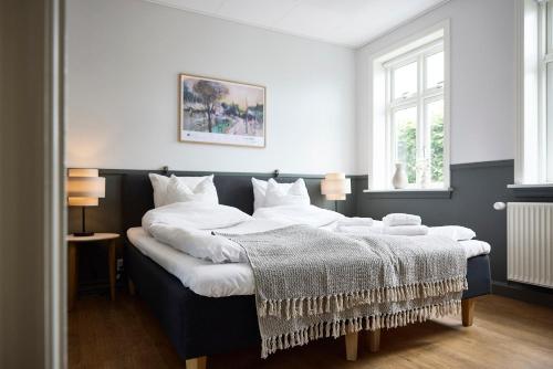 a bedroom with a large bed with white pillows at Westergaards Hotel in Videbæk