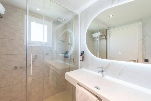 a bathroom with a shower and a sink and a mirror at Olive Beach Apartamentos in Port d'Alcudia