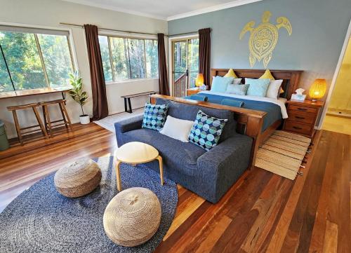 a living room with a bed and a couch at Cosy Studio with Forest Views, Noosa Hinterland in Doonan