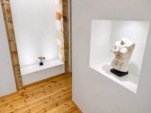 a sculpture sits on a shelf in a white room at Venetian Palace Chania - Adults Only in Chania