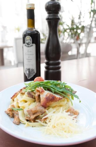 a plate of food on a table with a bottle of wine at Hotel Esplanade & Aparthotel Rialto in Binz