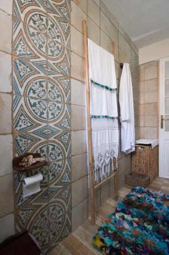 a bathroom with a wall with a patterned wall at Apartment Corinth in Korinthos