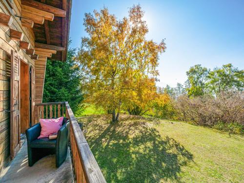 a porch with a blue chair with a pink pillow at Chalet Marinette in Icogne