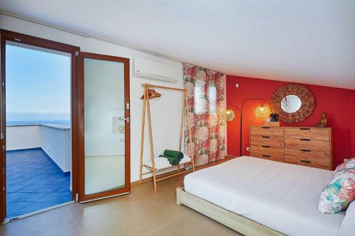 a bedroom with a bed and a sliding glass door at VILLA ANANDA in Scopello
