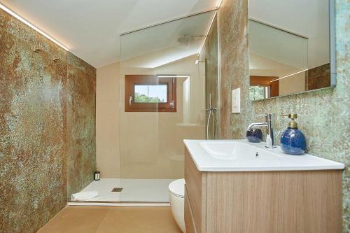 a bathroom with a sink and a toilet and a mirror at VILLA ANANDA in Scopello