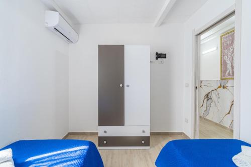 a bedroom with a blue bed and a mirror at Jungle Holiday Villa in Avola