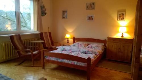 1 dormitorio con 1 cama, 2 sillas y ventana en Agroturystyka Zatom Stary, en Zatom Stary