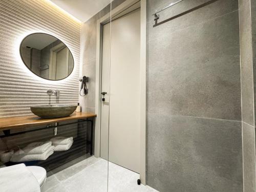 a bathroom with a sink and a mirror at Rêve Studio Apartments in Sarandë