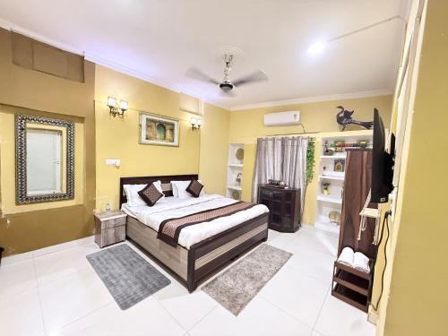 a bedroom with a bed and a television in it at Staylo Suites Edit in New Delhi