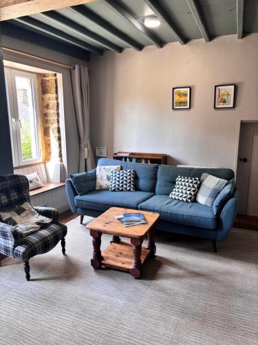 a living room with a blue couch and a coffee table at La Ramée - 2 bedroom - Wi-Fi - Garden - Parking in Saint-Siméon