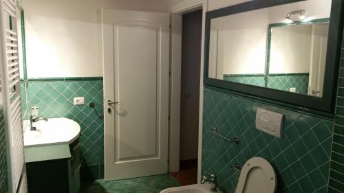a bathroom with a sink and a toilet and a mirror at Villa Sofia in Marina di Campo