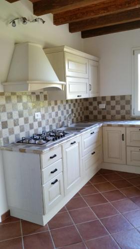 a kitchen with white cabinets and a stove top oven at Villa Sofia in Marina di Campo
