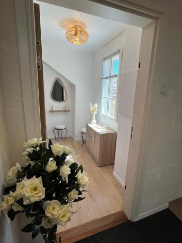 a room with a vase with white roses in it at L inattendu in Brie-Comte-Robert