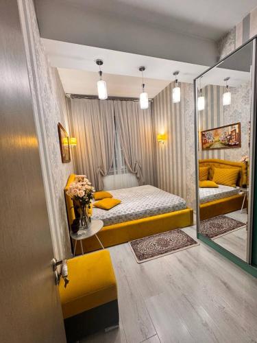 a bedroom with a yellow bed and a mirror at Zarisha Home in Fergana