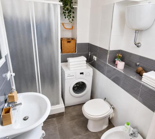 a bathroom with a washing machine and a sink at Maison La Reggia in Caserta