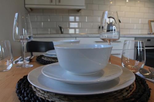a white bowl on a table with two wine glasses at Sundaywell Cottage in Killyleagh