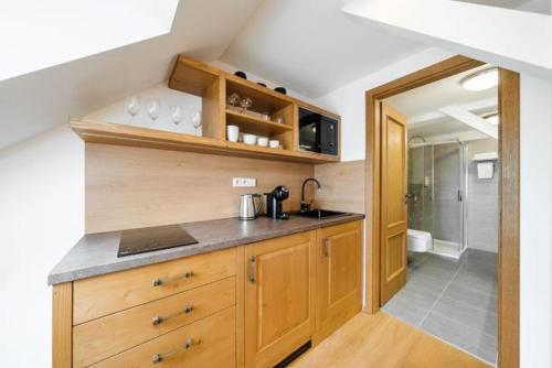 a kitchen with wooden cabinets and a sink at U Černého medvěda in Jablonné nad Orlicí