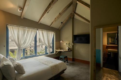 a bedroom with a bed and a large window at TONG Boutique Hotel in Phan Thiet