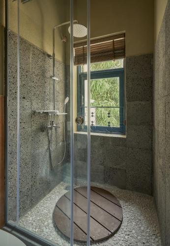 a bathroom with a shower with a glass door at TONG Boutique Hotel in Phan Thiet
